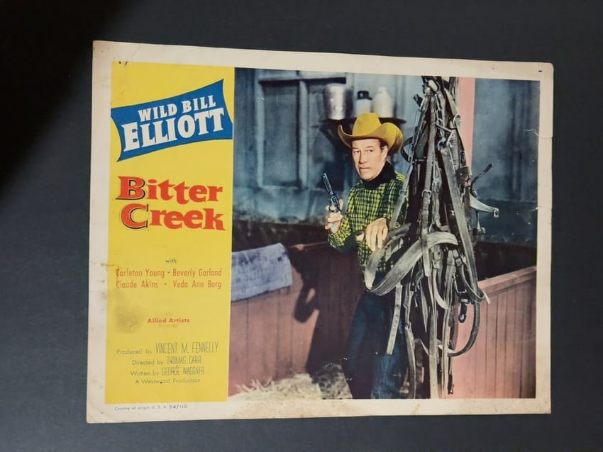 Bitter Creek Vintage Western Movie Lobby Card: Vintage lobby card for the Western Bitter Creek, starring Wild Bill Elliott with Carleton Young, Beverly Garland, Claude Akins and Veda Ann Borg. Color scene depicts Elliott beside horse tack holding 