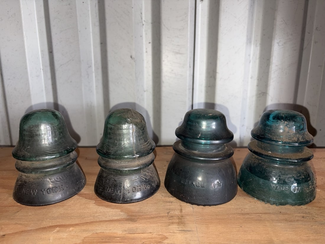 Antique New York Glass Utility Insulators (4): Group of four antique glass telegraph, telephone or electrical line insulators, including two examples embossed New York and additional embossed examples. Attractive aqua and green glass colors with