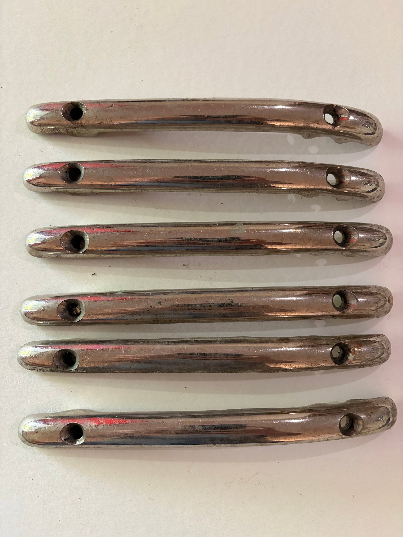 Set of 6 Vintage Chrome Automobile Exterior Trim Handles: Set of six matching vintage chrome-plated automobile exterior trim pieces or handles. Each elongated piece has mounting holes at both ends and streamlined rounded styling. Chrome shows scratches,