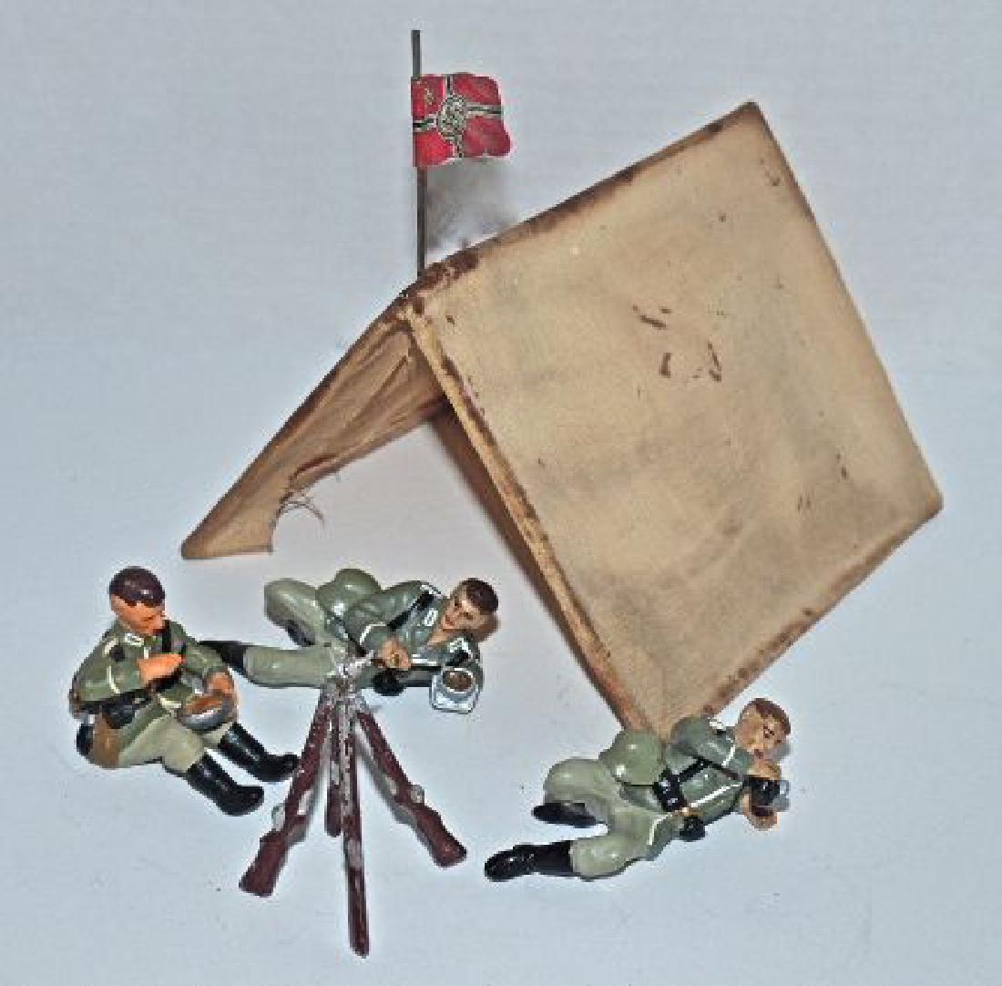 Lineol Krock Tent-Rifle Stack 3 Camp Figures: Tent unknown maker. 5 inches deep and 3 inches high. Cloth shows wear and staining but no rips/ tears. Tin flag is original Hausser. The Lineol rifle stack is complete with light wear. The 3 Krock cam