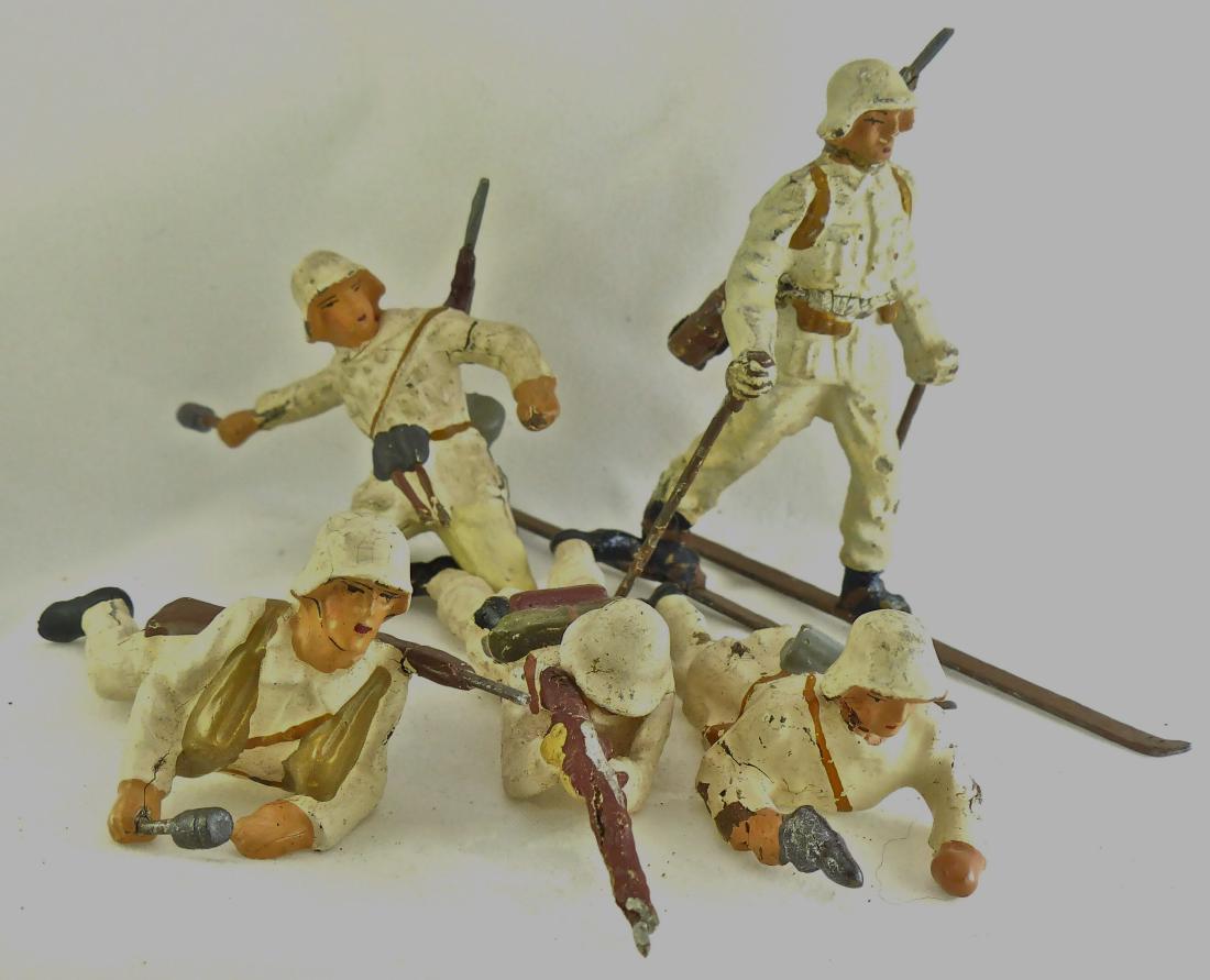 Lineol/ Elas. 5 German Soldiers Winter Uniforms: Elastolin prone with rifle is original and excellent. No catalog info. The helmets are all Swiss/ Danish except for the soldier on ground with HG and Rifle. A German helmet on a Lineol Winter uniform 