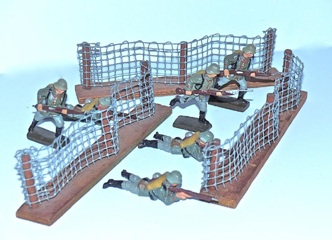 Lineol 6 6.5 CM Germans and 3 Wire Sections: Soldiers have a few small cracks with one rifle butt missing. Paint quality is excellent. Made 1928-32. 3 wire sections with wood posts and bases are Post War. They are just over 7 inches across and 2
