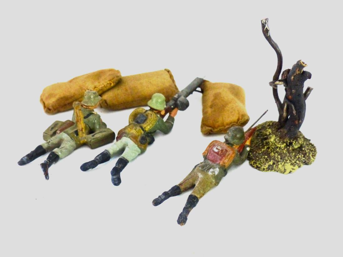 Lineol Machine Gun 3 Sandbags 2 Soldiers: 3 Figures with some touch-up and a couple of cracks. Paint and detail very good. Sand bags with no tears. Cast tree without damage and postwar as well as sand bags. 7 Pieces. 7.5 cm. Figures made abou