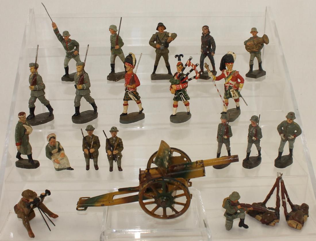 Lineol Elastolin Composition Lot with Gun: Lot is comprised of 6cm and 7cm assorted combat figures including 2 seated gunners, tin howitzer, rifle stacks, Luftwaffe pilot, and 3 Elastolin Highlanders. 22 pieces. Condition fair to good. Cannon 