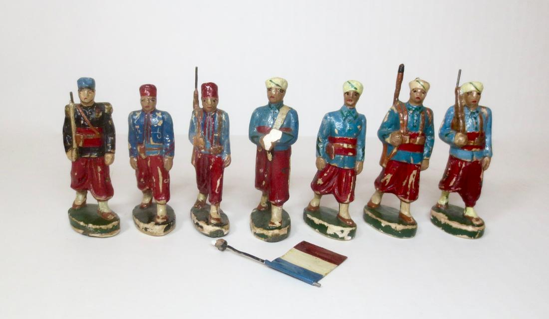 French Composition Zouaves and Turcos Marching: Unusual 60mm scale French Composition figures. 7 pieces. Good to fair condition (with paint loss, two gun tips damaged, and flagbearer's hand with flag broken off). Unboxed.
