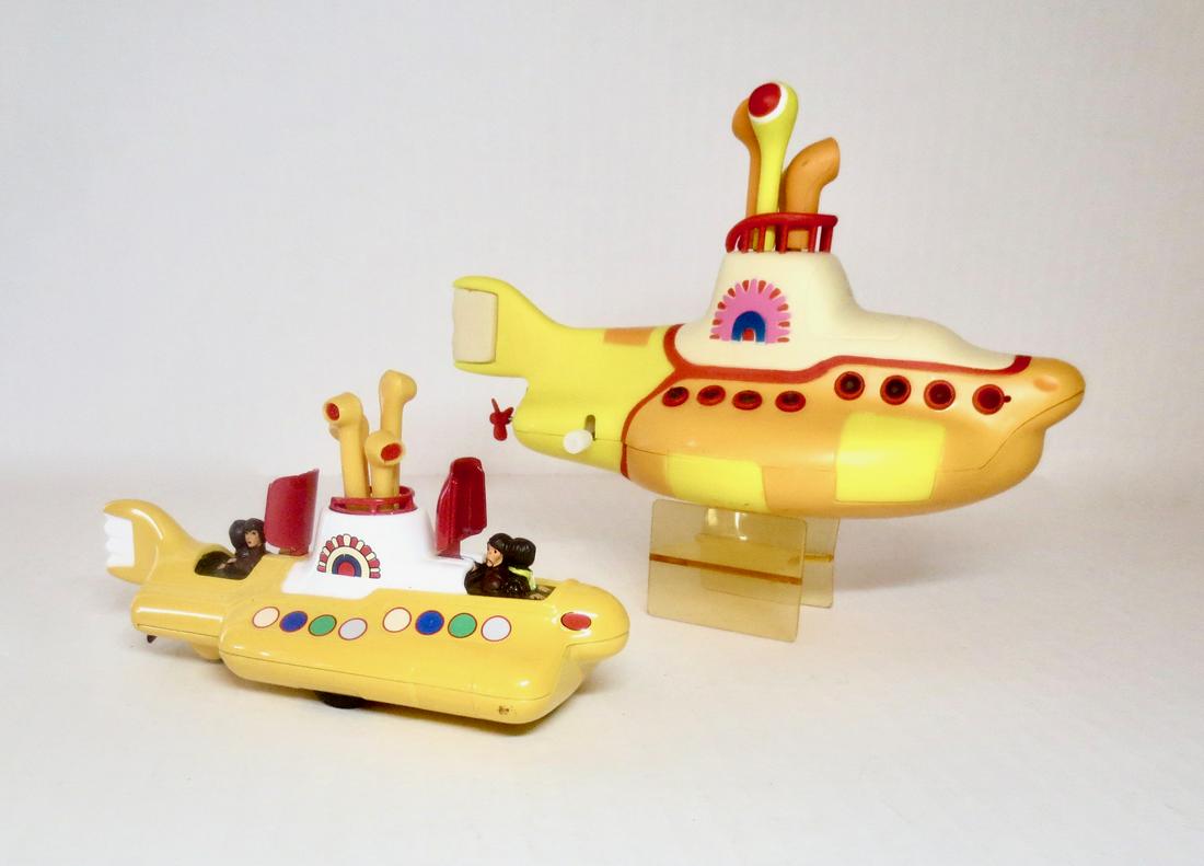Corgi & Other Beatles Yellow Submarines: Diecast metal Corgi Yellow Submarine and other maker plastic wind-up Yellow Submarines. 2 pieces (plus stand). Excellent condition. Unboxed.