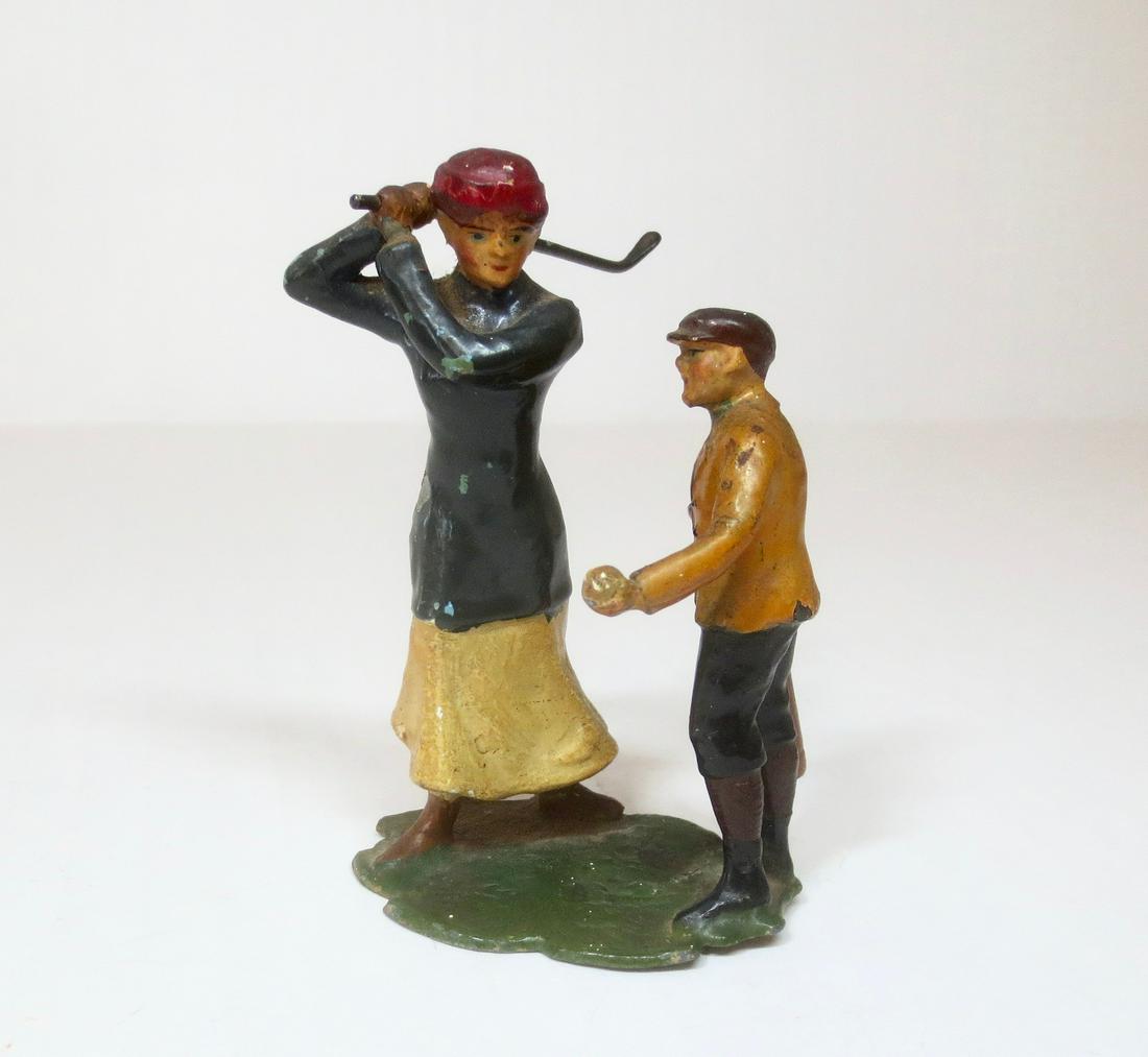 Heyde Woman Golfer with Caddy: Lovely Heyde vignette of a Woman Golfer taking a swing, while her caddy provides some helpful tips. Measures 3" tall. Excellent condition.