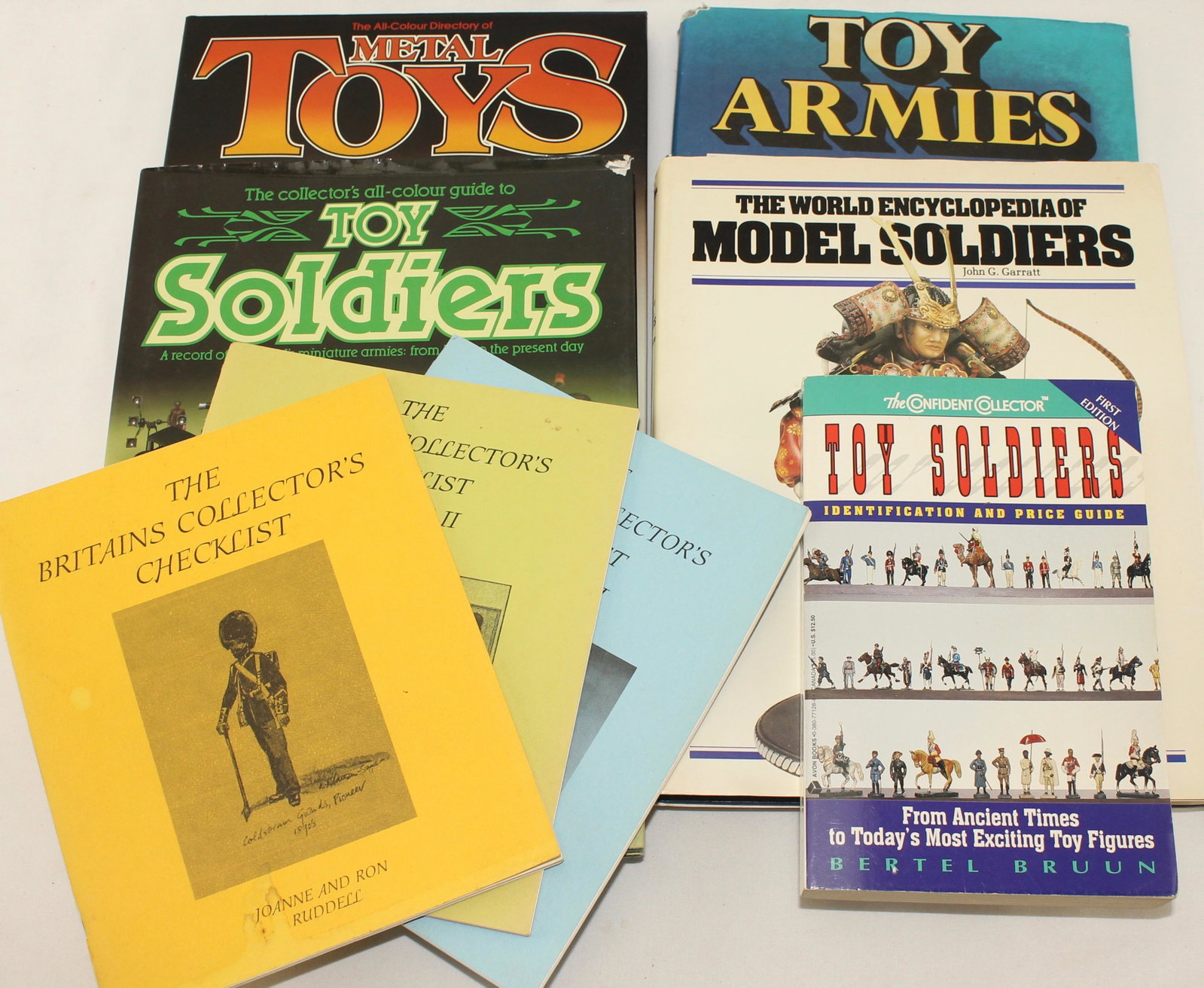 Lot of Books on Toys and Toy Soldiers: Lot of Books on Toys and Toy Soldiers. Includes John Garrett's Encyclopedia of Toy Soldiers, Toy Armies by Peter Johnson and a 3 Volume Britains Checklist by Joanne and Ron Ruddell. 8 Pieces. Conditio