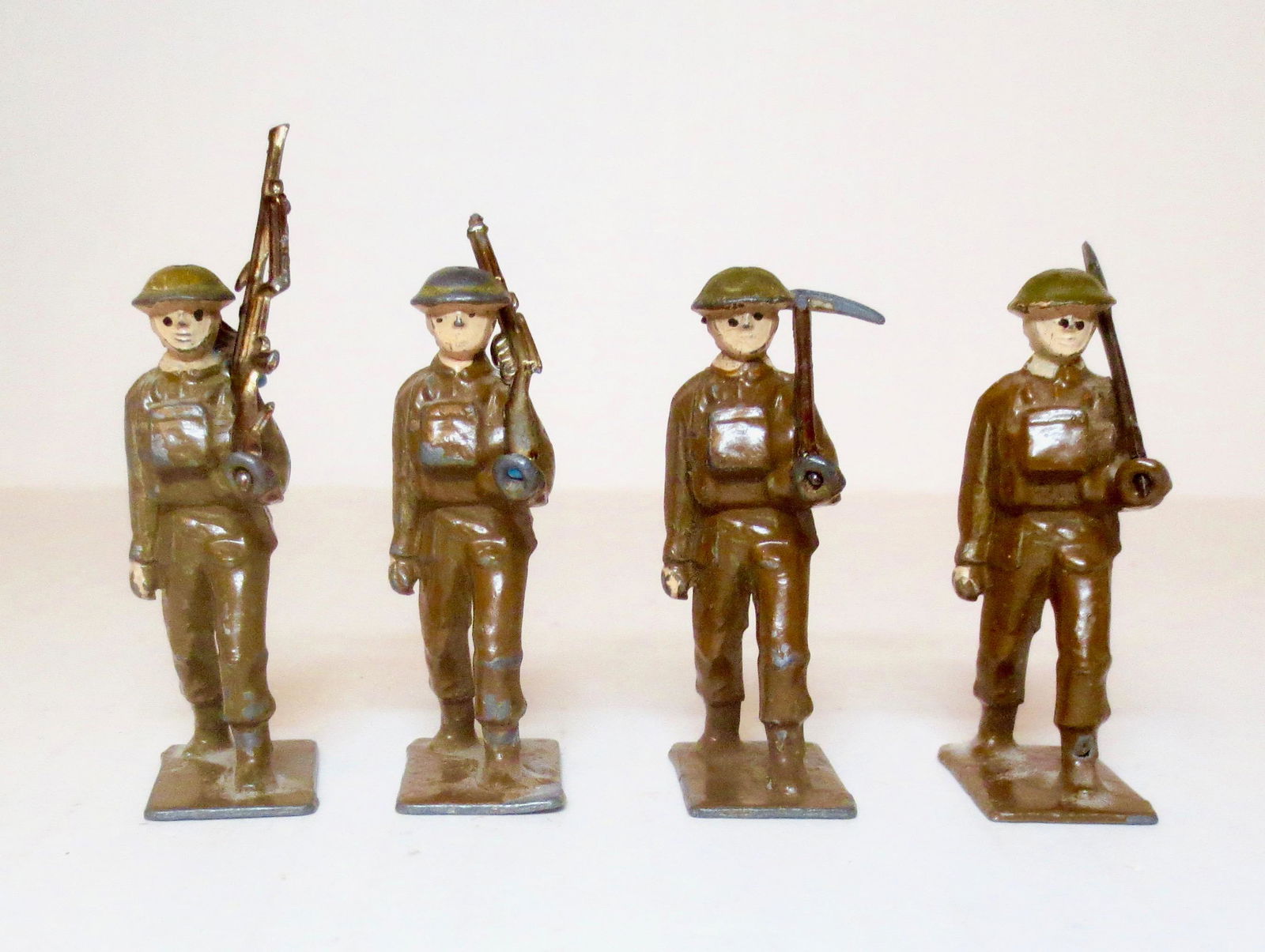Johillco RARE Infantry & Interchangeable Weapons: Unusual Khaki Infantry with Steel Helmets and "Ring Hands" designed to hold various weapons and tools. These figures are holding a bren gun, rifle, pick axe and shovel. Pre war. 4 pieces, and 4 tools.