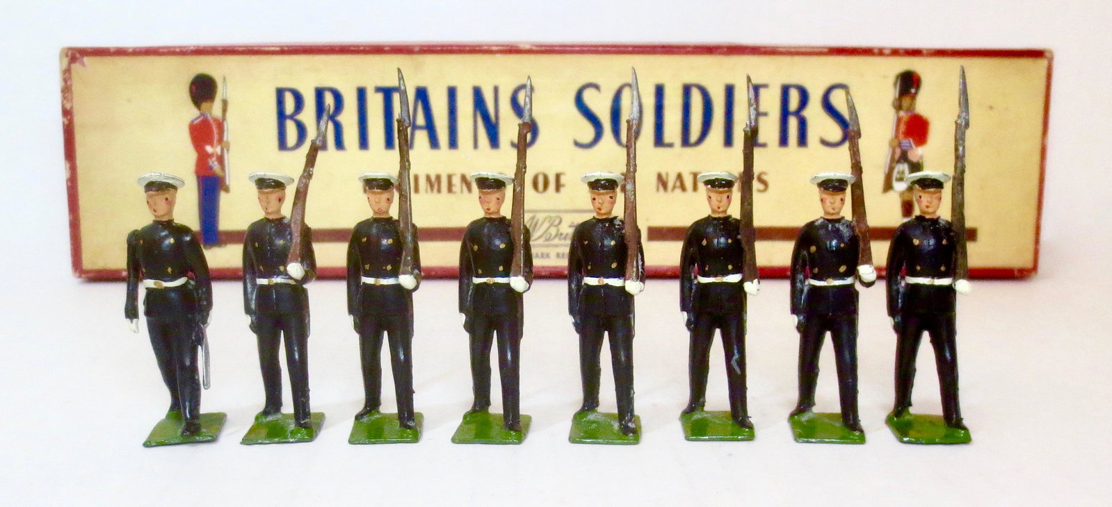 Britains #1835 Argentine Naval Cadets: Argentine Naval Cadets, marching at slope with officer. Post war, with original ROAN box. 8 pieces. Excellent condition. Box very good (some edge wear, and a bit of wear on side label).