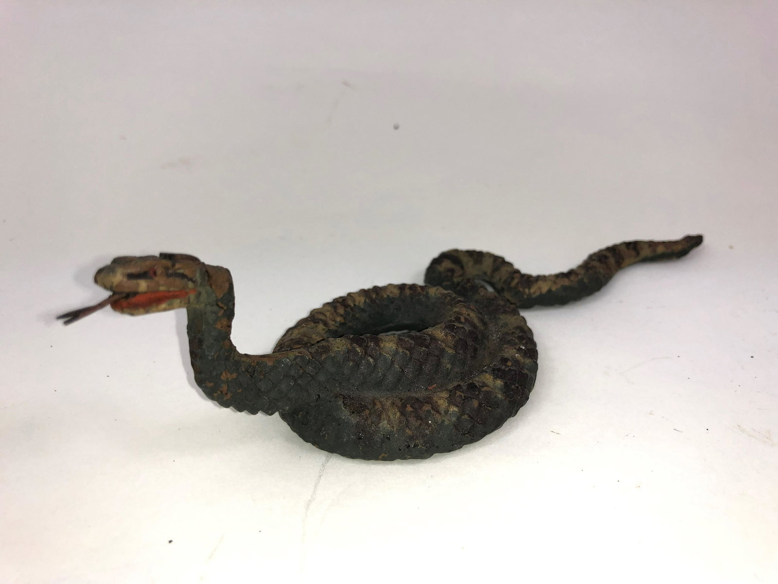 Lineol Composition Rattlesnake: One piece composition in good condition with crack in his head. In the mold he is stamped "Germany." He is about 6 inches long.