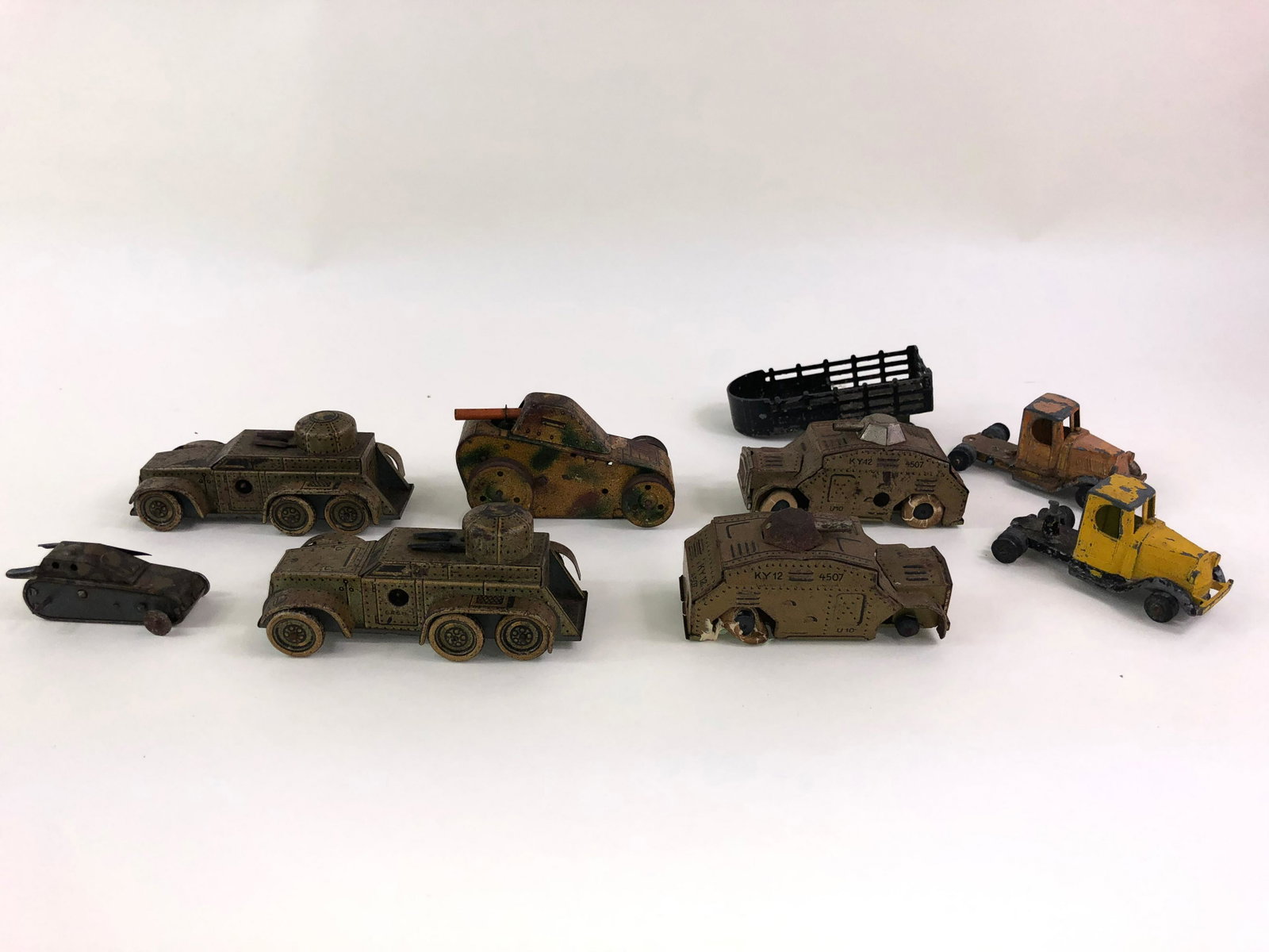 Tin Armoured Car and Tank Collection: 9 pieces in fair to good . The largest about 4 inches long. Some wheel and tire melting. Many marked "DRGM" . Three are Tootsie toy white metal.