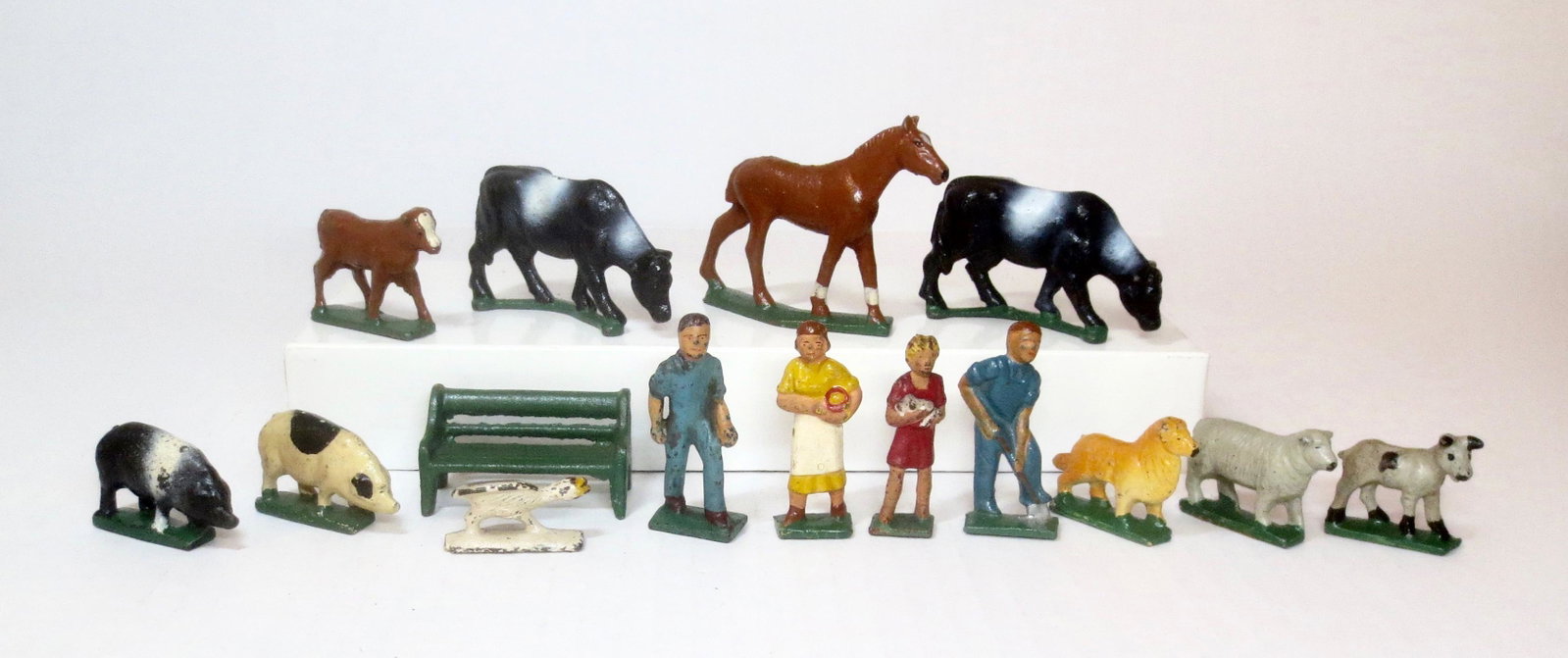 Grey Iron American Family on The Farm: Includes: "Calf", two "Cows", "Horse", two "Pigs", "Bench", "Goose", "Farmer", "Farmer's Wife", "Farm Girl", "Collie", "Sheep" and "Goat". 15 pieces. Excellent condition. Unboxed.