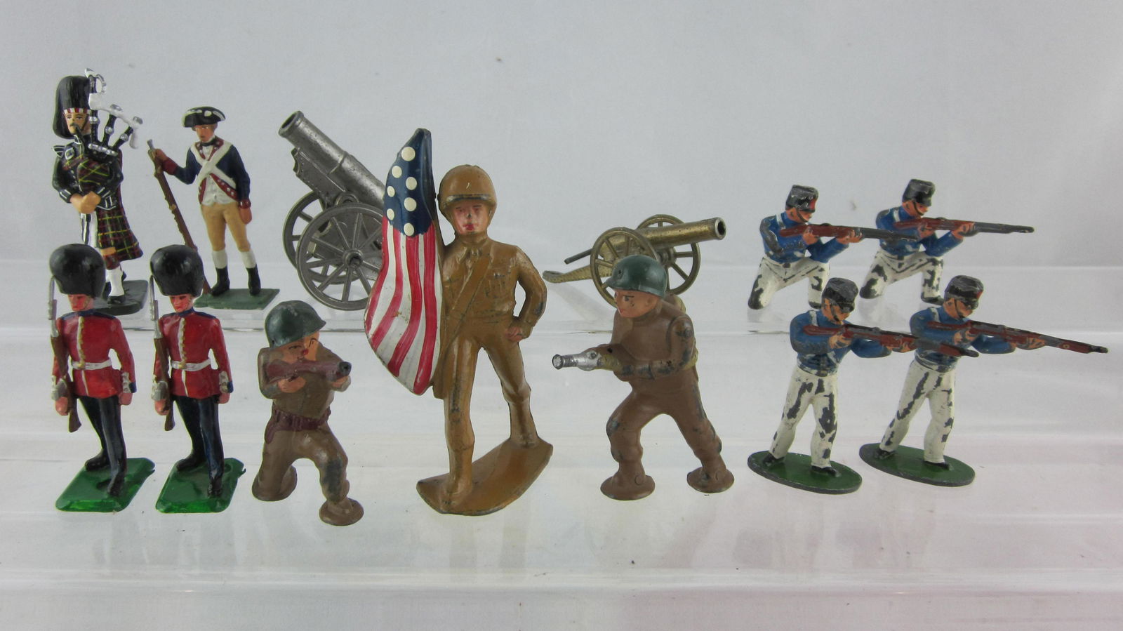 Varied Maker Soldier & Cannon Assortment.: UNBOXED 3 Dimestore figures, 4 Timpo West Point Cadets, 2 unknown Guards, Piper, Revolutionary War minuteman with 2 cannons. 13 pieces. Condition poor to excellent, 1 Dimestore figure rifle barrel gon