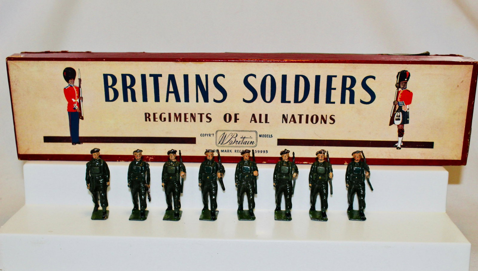 Britains set #2010 Airborne Infantry: Postwar "Red Devils" set. 8 pieces. Officer with swagger stick, Bren Gun at trail, six with slung rifles. Condition good/very good, a few berets chipped. ROAN box fair, taped bottom, no tie-card.