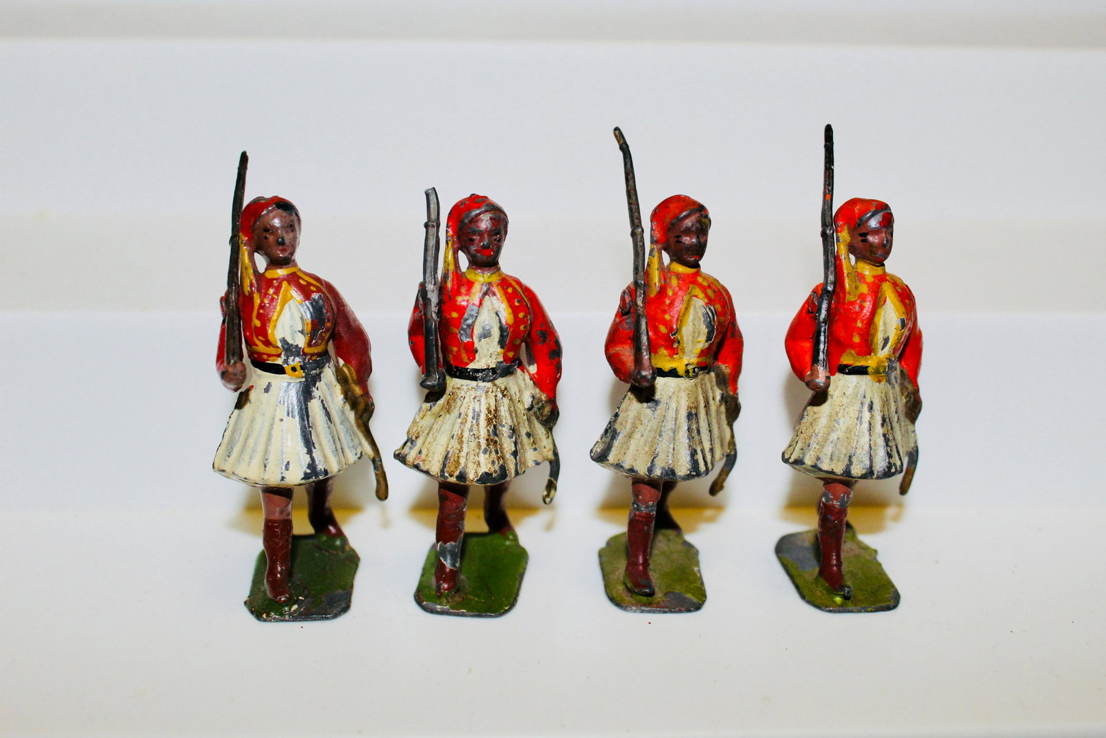 From Britains set #196 Greek Evzones: Prewar Evzones in scarlet vests. 4 pieces. Condition poor/fair, paint chips, one missing rifle end.