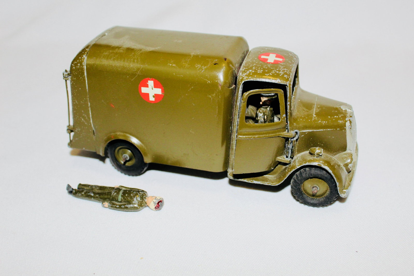 Britains set #1512 Army Ambulance, Motor Type: Postwar (1946-57) version with driver, open windshield, wounded man (missing right foot), no stretcher. Condition good/very good, driver paint chipped, small spots mostly on top of cab. No box.