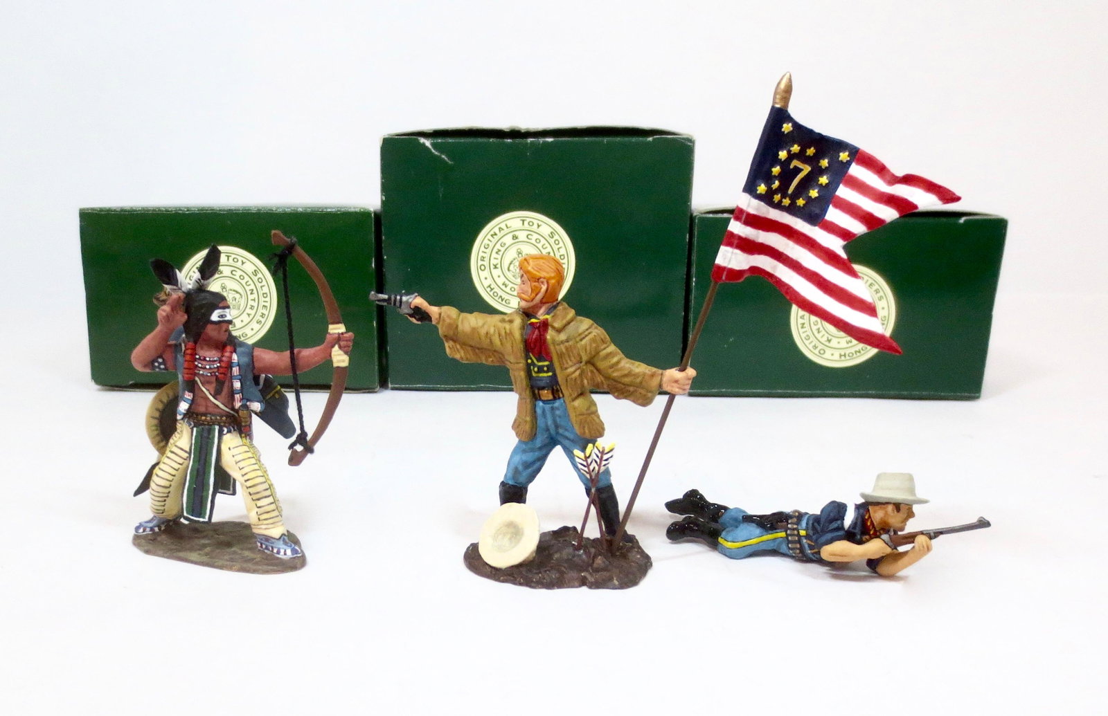 King & Country "The West" Figures: Includes; #TRW031 Indian Firing Bow, #TW028 George Armstrong Custer with Flag, and #TW027 Cavalryman Lying Prone. Retired figures. 3 pieces. Near mint condition. Boxes good.