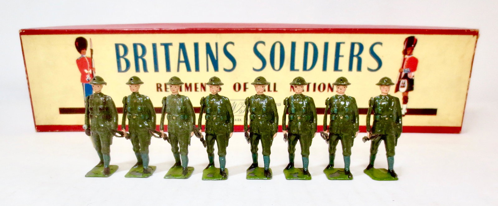 Britains #195 British Infantry: Marching at Trail. Post war issue. 8 pieces. Very good to good condition, with some paint loss primarily to the bases. ROAN box in good condition.