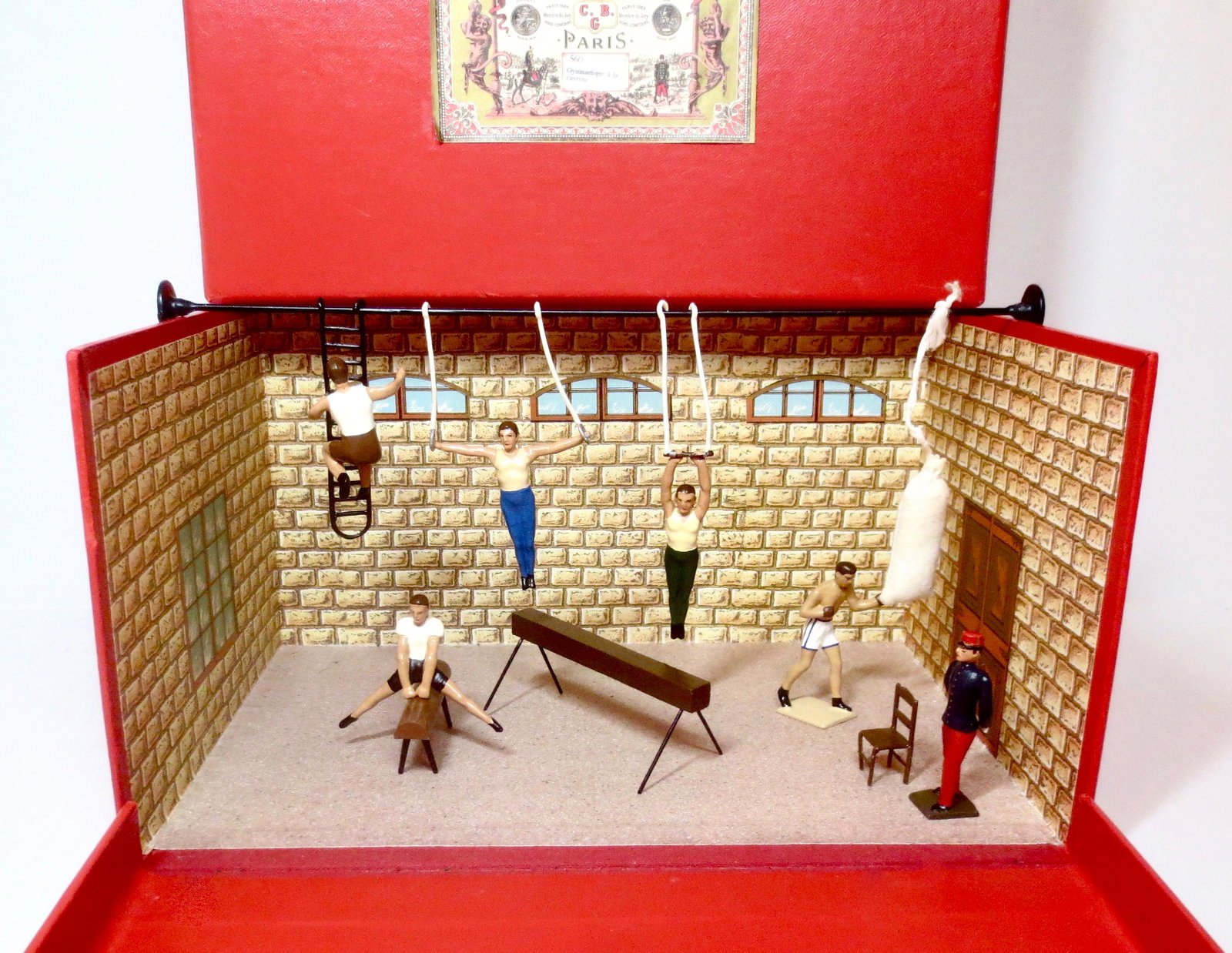 Mignot #560 "Gymnastique 'a la Caserne" Diorama: French Officer watching the troops as they exercise in the gym. 10 pieces. Excellent condition. Box excellent.