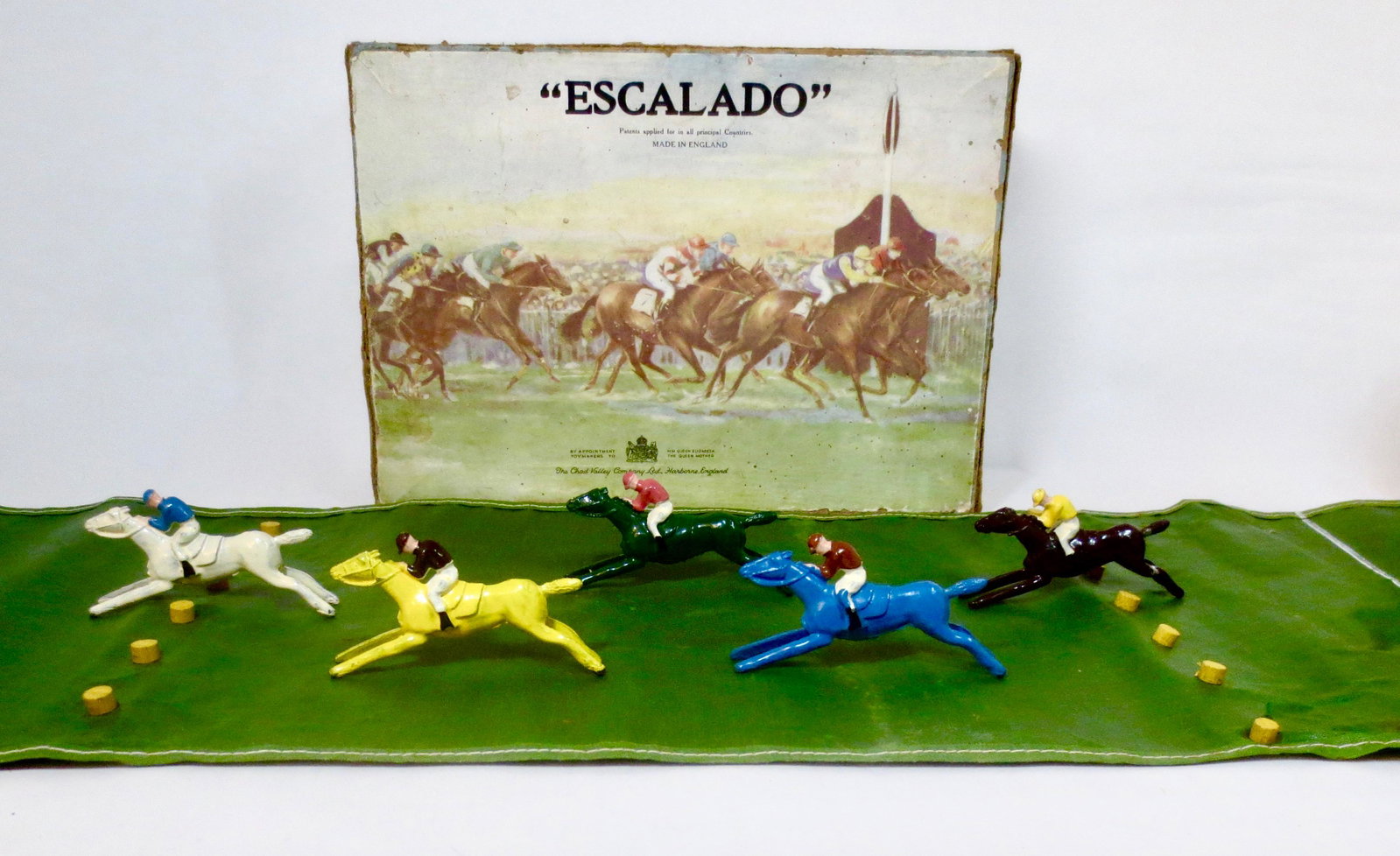 Chad Valley "Escalado" Horse Race Game: Includes 5 Jockeys on Horses. Plus race course mat. Includes directions on the underside of the lid. Excellent condition, with original illustrated box. Box fair, with surface wear, and corner splits.