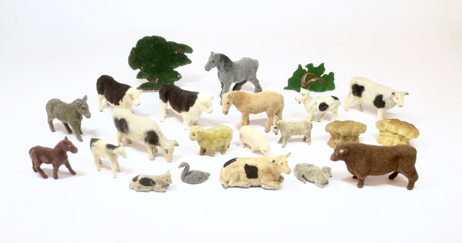 Flocked Farm Animal Assortment: Variety of farm figures, trees and hay stacks - all flocked. Assorted makers. 22 pieces. Near mint to excellent condition. Unboxed.