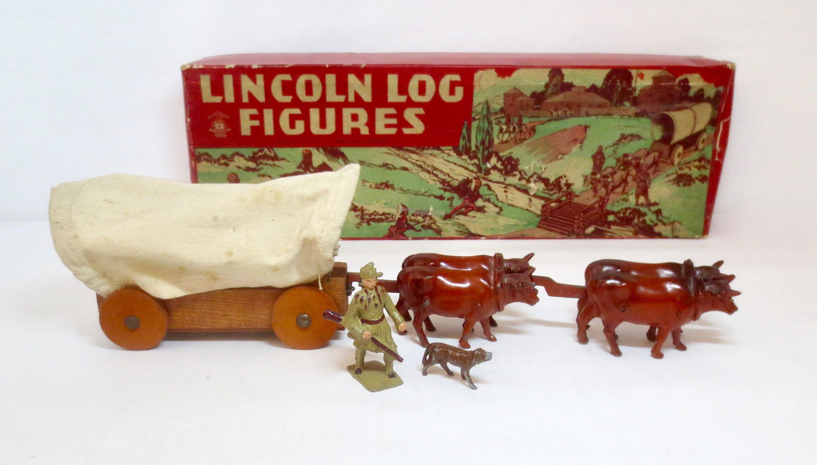 Lincoln Logs Conestoga Wagon Set: Rare set, features a Conestoga Wagon being pulled by Oxen. Plus Pioneer with Dog figures. 5 pieces. Near mint condition. Box good, with surface wear, a few small punctures, and splits on one end flap)