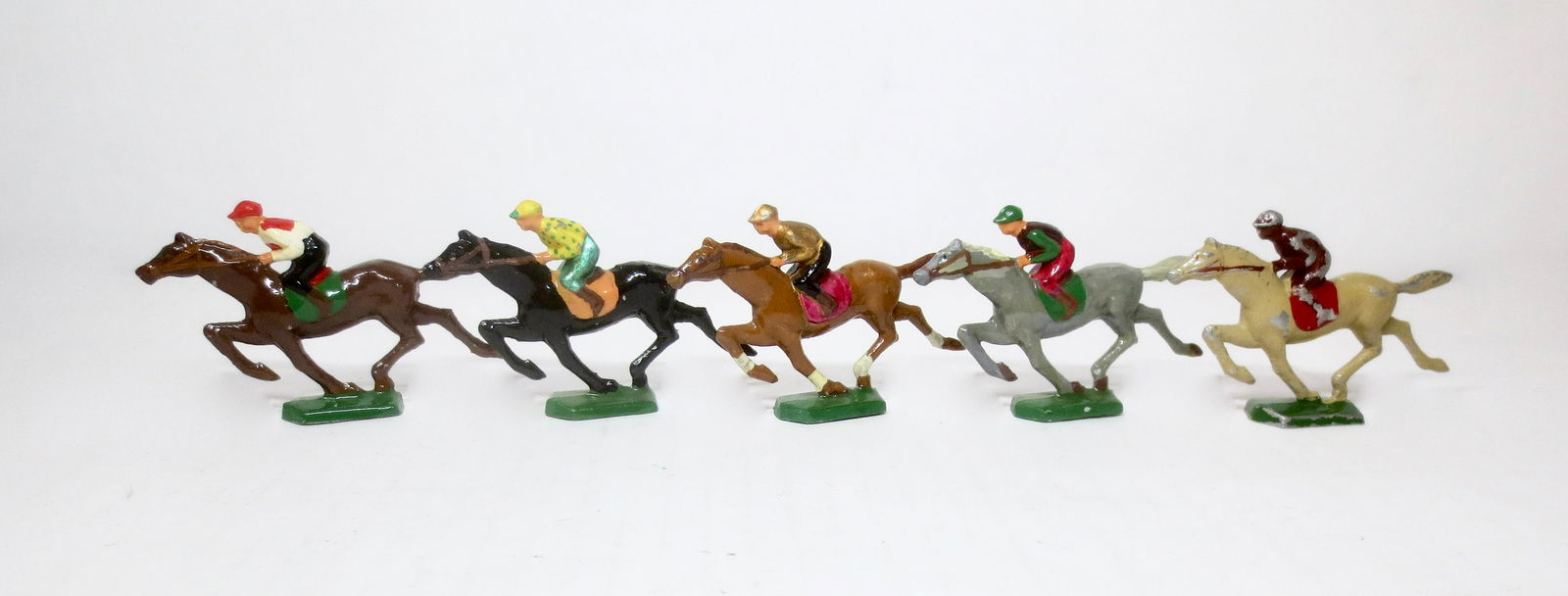 Vintage Lead Race Horse Set: Colorful Jockeys on galloping horses. Possibly vintage game pieces. 2"tall. 5 pieces. Excellent overall condition (one horse with paint loss). Unboxed.
