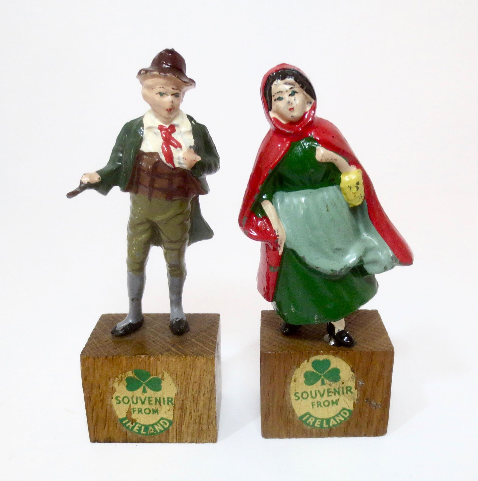 Heyde Irish Souvenir Figures: Lass in Red Hooded Cloak, and Lad with cane under his arm. 4" tall including the bases. Excellent condition.