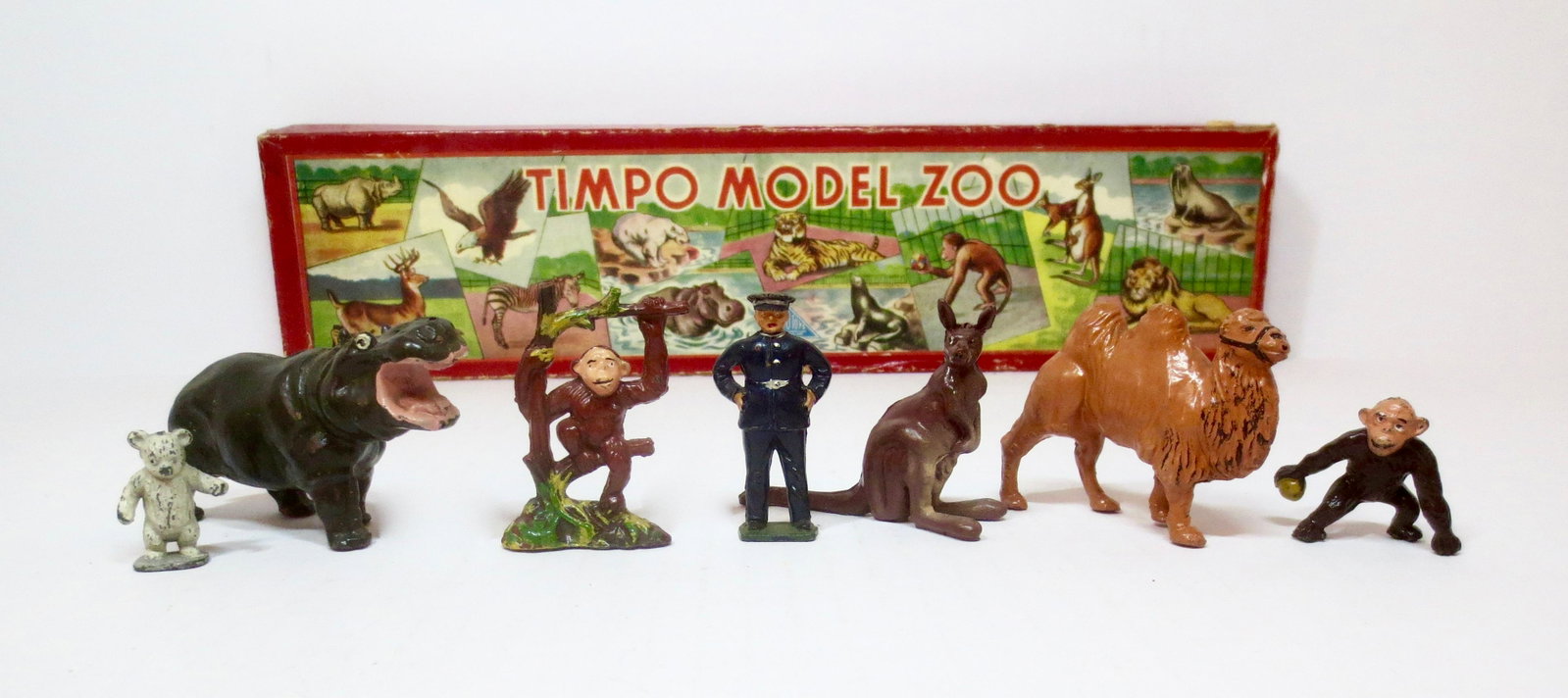 Timpo Model Zoo Set: Includes a Hippo, Polar Bear Cub, Monkeys, Camel, Kangaroo and Zoo Keeper. 7 pieces. Near mint to excellent condition. Box good, with surface and edge wear.