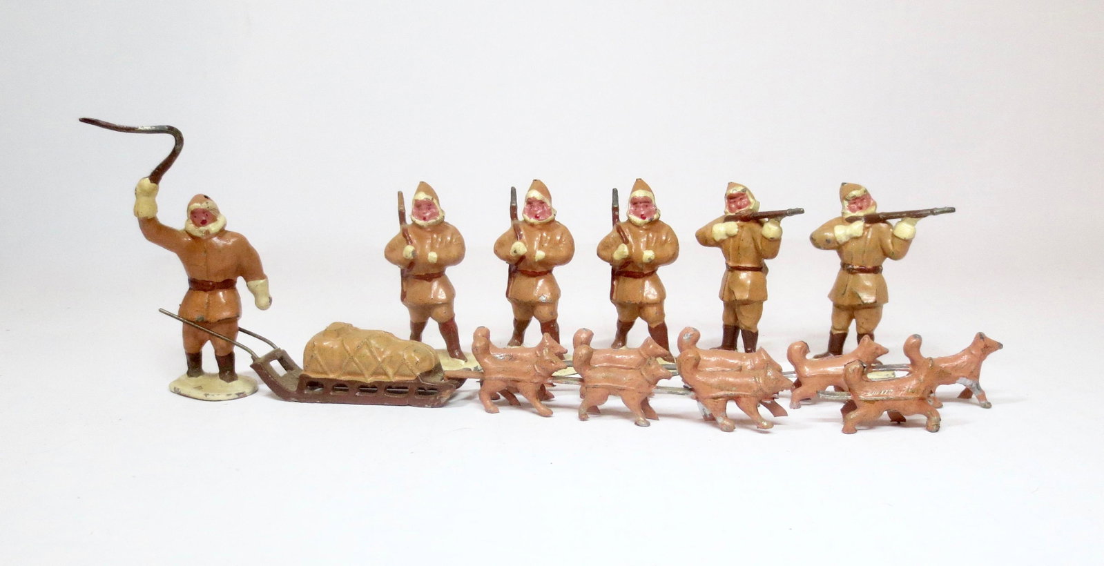 D.C. France Eskimos Set: Similar to the Timpo set, but made in France by D.C. Eskimos marching and firing rifles, with Eskimo driving a dog sled. 9 pieces. Excellent overall condition (one hook missing from harness, one dog b