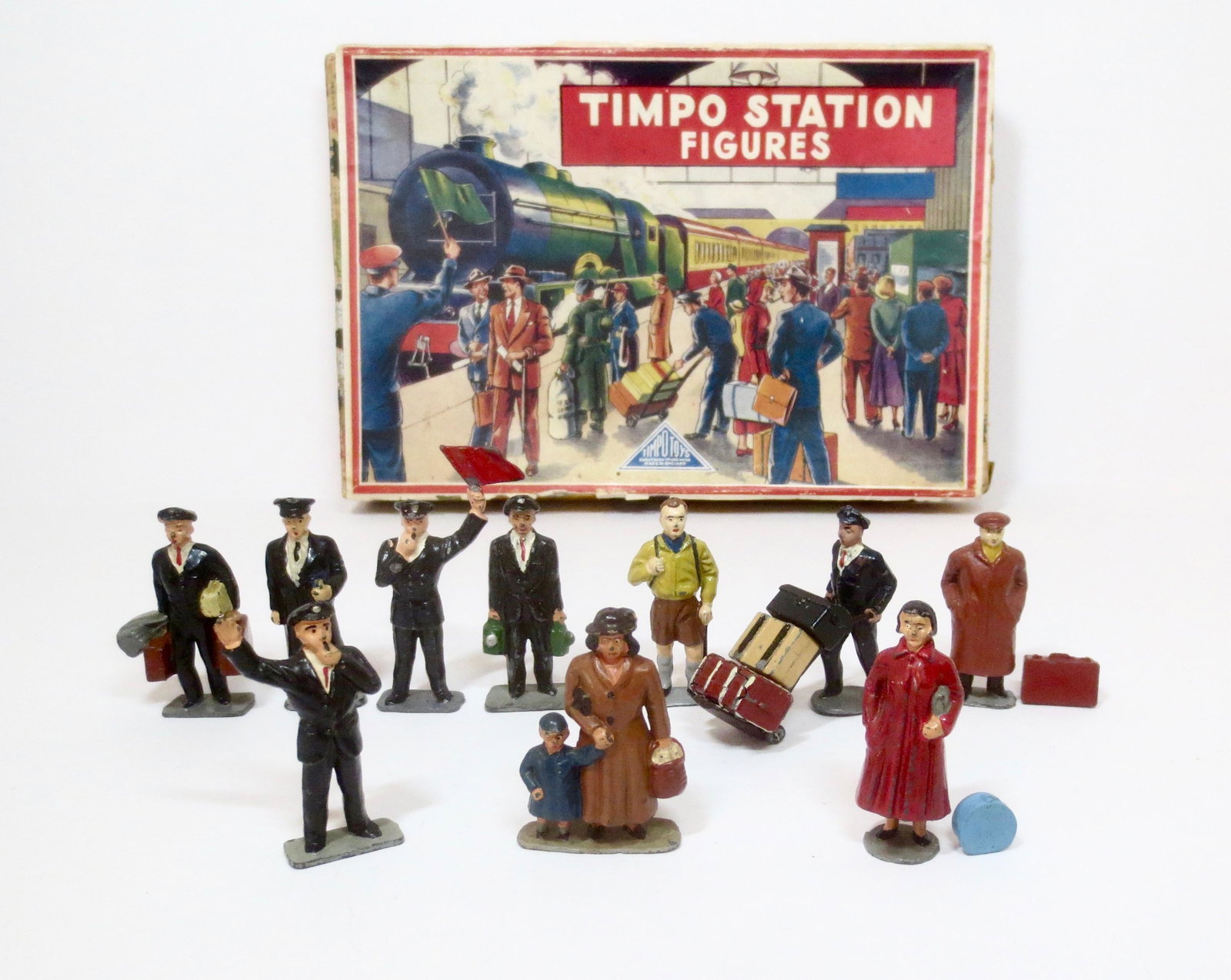 Timpo #830 Station Figures: Railway station crew and passengers. 16 pieces, including luggage. Near mint to excellent condition (one suitcase has metal fatigue). Comes with original illustrated box. Box very good, with edge wear