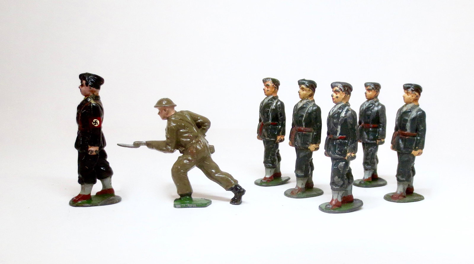 Timpo Military Assortment: British Tommy with captured Nazi (repainted), and U.S. Soldiers in Ceremonial dress. 7 pieces. Excellent to very good condition. Unboxed.