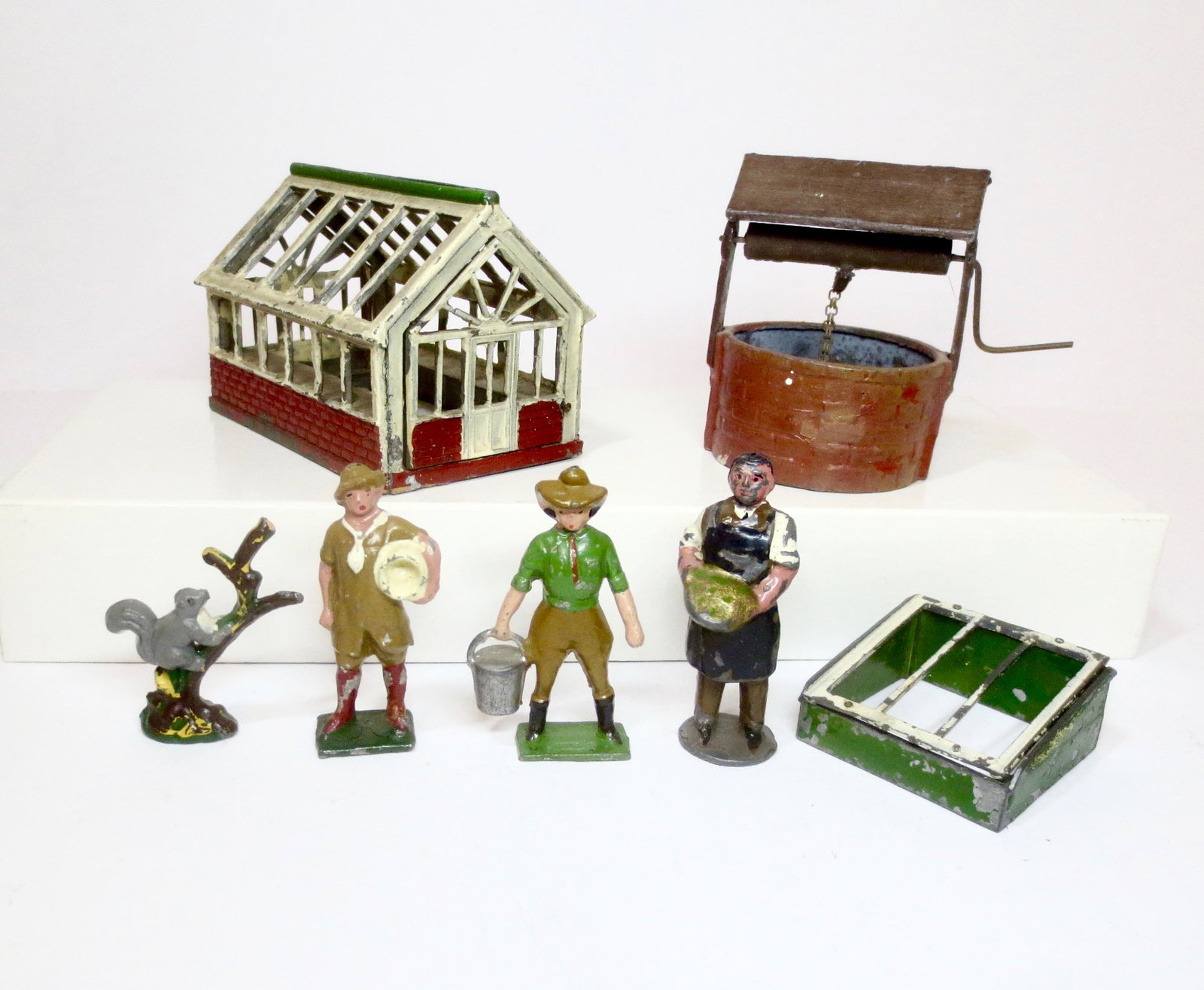 British Makers Farm & Garden Assortment: Johillco Greenhouse, Water Well (no bucket), and Market Gardener. Plus a Timpo squirrel climbing a tree, Pixyland and Fylde Land Girls, and a Britains Span Garden Box. 7 pieces. Excellent to good cond