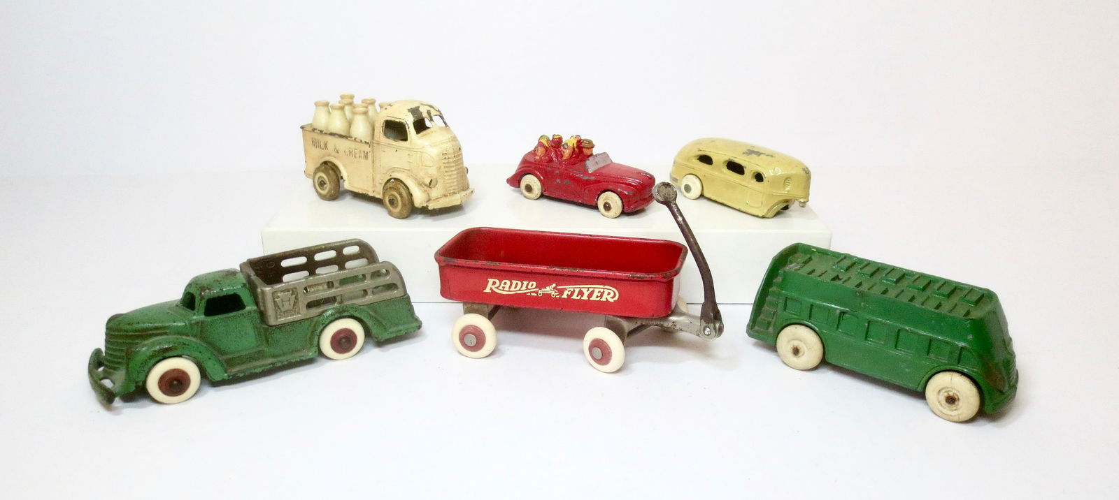American Dimestore Toy Vehicles: Cast Iron Stake Truck and Radio Flyer wagon, with a variety of slush toy vehicles. 6 pieces. Excellent to very good condition. 3 with replacement wheels.
