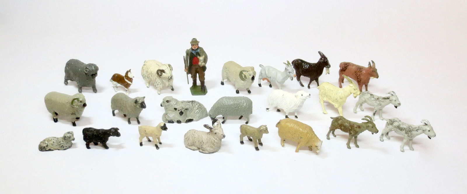 British Makers Farm Assortment: Britains Shepherd holding a baby lamb, his trusty Collie Dog, and an assortment of Goats and Sheep from a variety of makers. 23 pieces. Excellent condition. Unboxed.