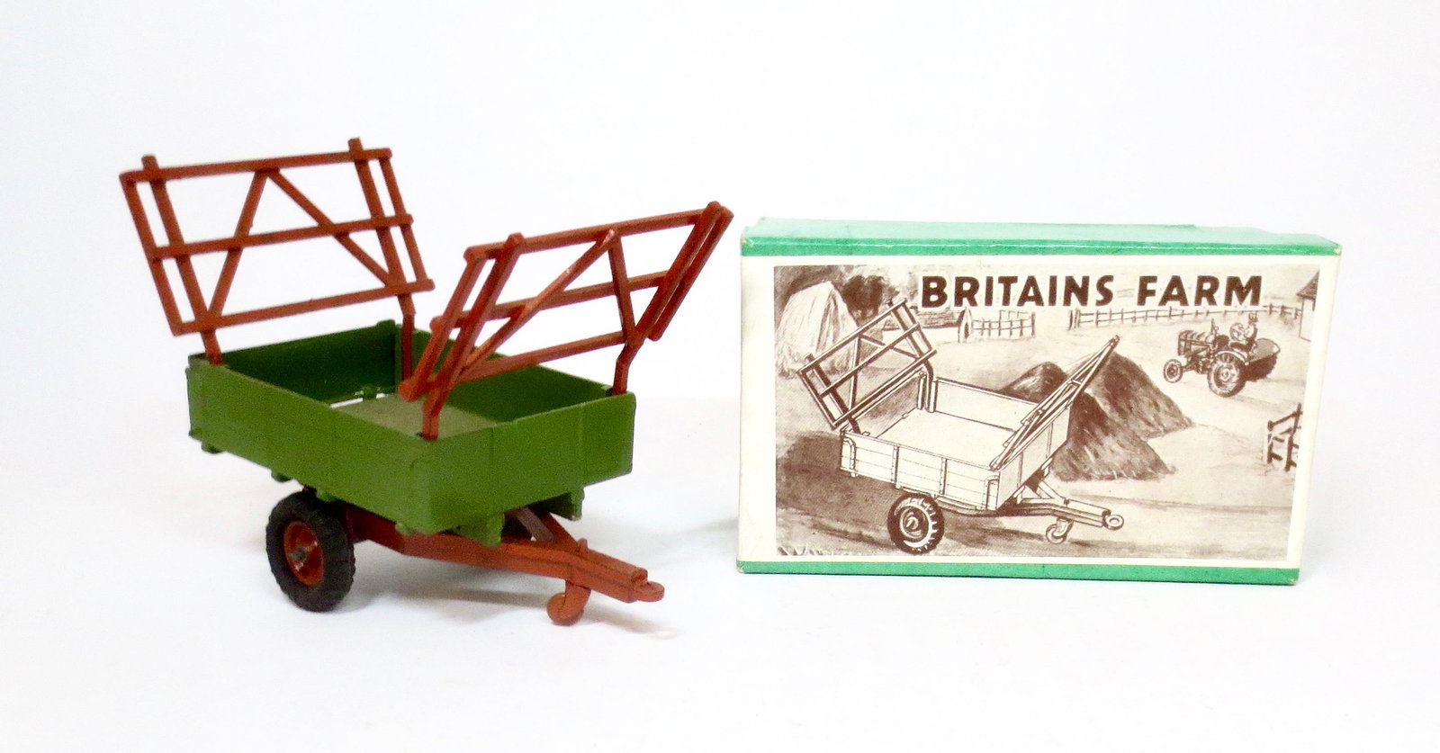 Britains #130F Farm Trailer: Farm Trailer with green body, tan chassis and hay racks. 3 pieces. Near mint condition. Box excellent.