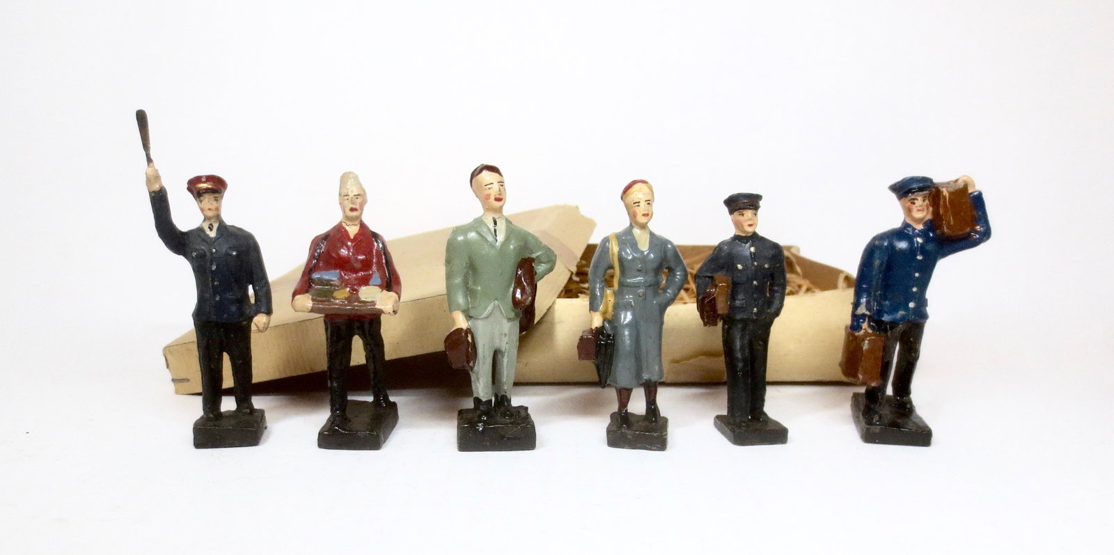 Leyla Composition Train Figures Boxed Set: Railway Porter, Bell Boy, Vender, Flagman and Passengers. 75mm tall. 6 pieces. Near mint to excellent condition, with original box and excelsior packing. Box fair.