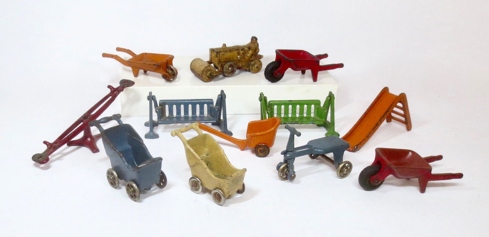 Cast Iron Toy Assortment: Baby Buggies, Porch Swings, Wheelbarrows and more. 1-1/4" to 2" tall. 12 pieces. Excellent condition.