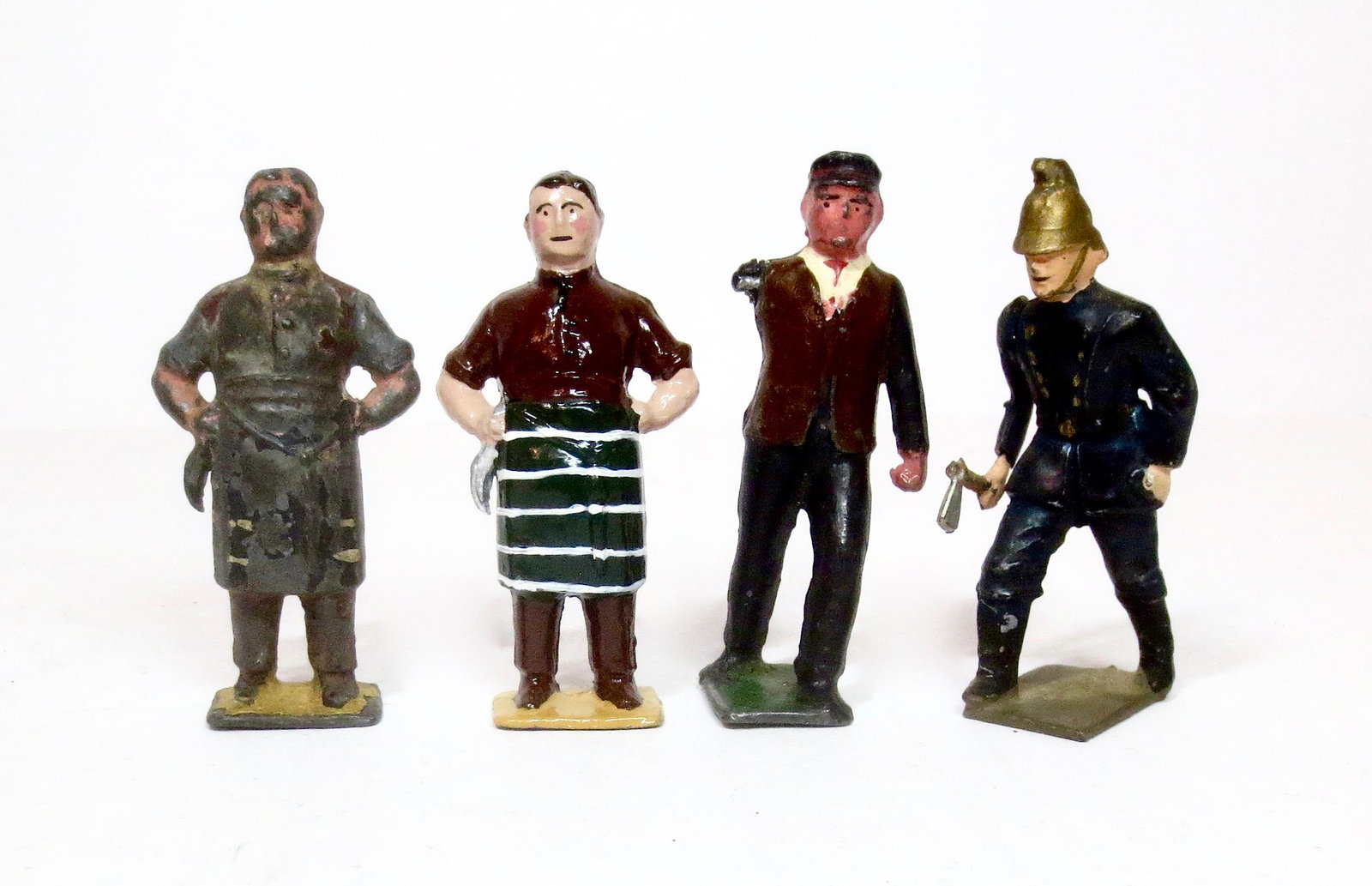 Pixyland Figures: Two Butchers, one with paint loss and one repainted, Conductor (missing arm), and Fireman with Axe in excellent condition. 70mm tall. 4 pieces. Unboxed.