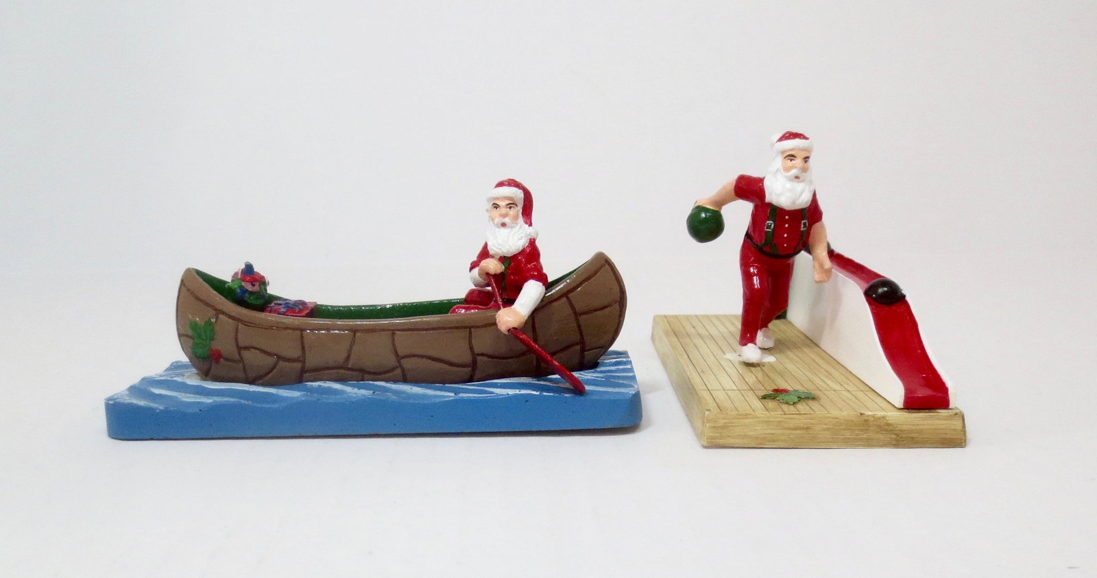 Santa Claus in Canoe and Bowling: Whimsical vignettes. 2 pieces. Excellent to very good condition (Santa has come loose from the bowling alley, chip on alley). Both in plain brown craft boxes.