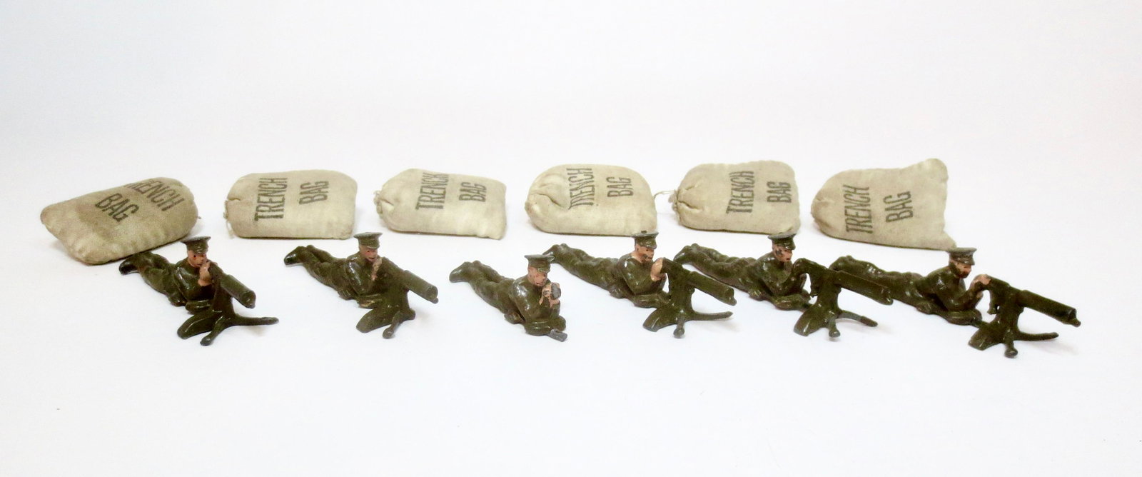 Britains From #194 Machine Gun Section: Pre war issue. Gunners in Peaked Hats with Trench Bags from a different maker. 12 pieces. Very good condition with some paint loss and one broken gun. Unboxed.