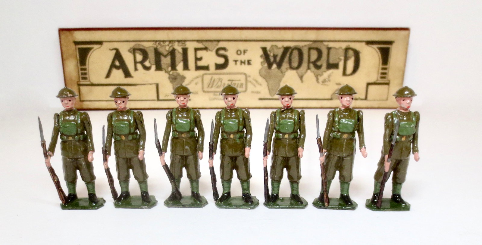 Britains #1828 Infantry of the Line: At Ease with Shrapnel Helmets. Pre war issue in Armies of The World box. 7 pieces. Nicely repainted condition. Box in fair condition, with one top corner split, one top label repair, and mismatched bo