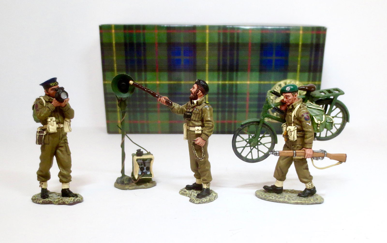 King & Country #DD054 “Beachmaster”: Royal Navy Commander Colin Maude directing traffic on “SWORD BEACH”. A Royal Navy signaler, a radio loudspeaker and a bicycle-carrying Commando. Set is missing dog. Retired set. 4 pieces. Near min