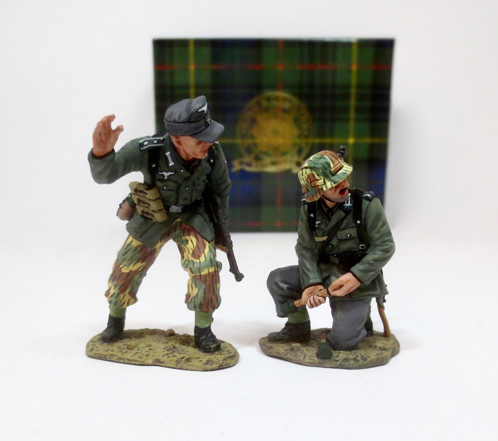 King & Country #WS117 “Get Ready!”: As one Wehrmacht Panzer Grenadier watches the advance of the enemy another prepares to pull the pin on his “potato masher” grenade. Retired set. 2 pieces. Near mint condition. Box excellent.