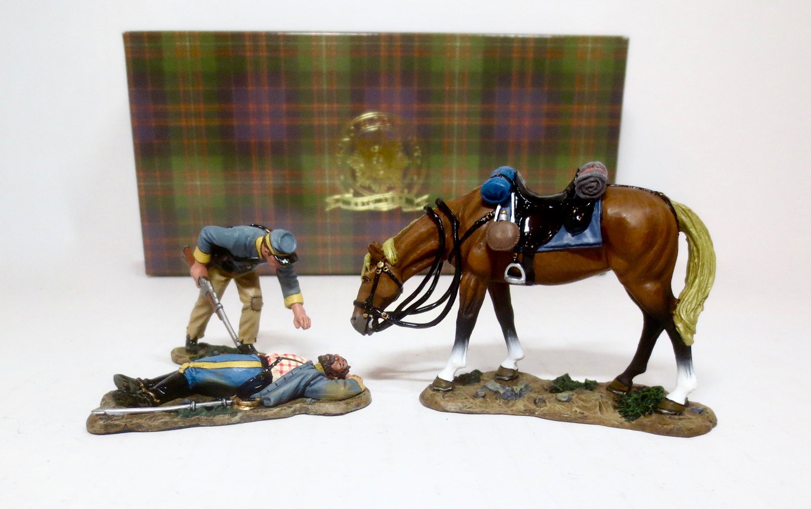 King & Country #CW048 "Helping A Friend": Retired set. A Confederate trooper dismounts to examine a fallen comrade as his forlorn horse looks on. 3 pieces. Mint condition. Box excellent.