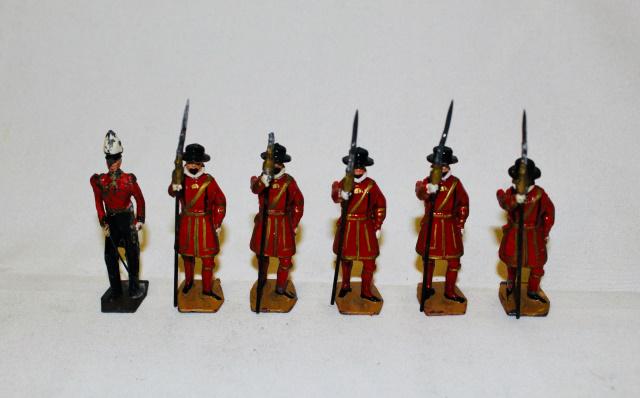 From Britains Set #1257 Yeomen of the Guard: Postwar. 6 pieces. Condition fair/good, one halberd end missing, officer dark brown base, troopers' sand colored, gold swag on halberds. No box.