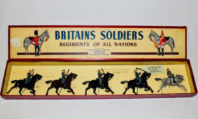 Britains Set #2055 Confederate Cavalry: Postwar. 5 pieces. Condition good. Paint chipping on officer's horse and legs of troopers' horses, one rifle broken at hand but present. Untied in ROAN box very good.