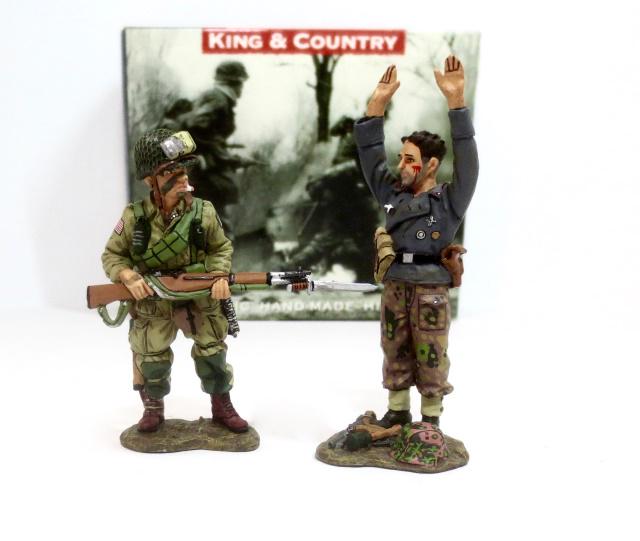 King & Country #DD074 “Reach for The Sky”: Based on a famous photograph, this young paratrooper has captured a tough-looking crewman of a German Assault Gun. Retired set. 2 pieces. Near mint condition. Box excellent.