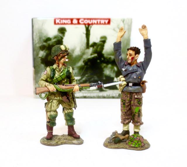 King & Country #DD074 “Reach for The Sky”: Based on a famous photograph, this young paratrooper has captured a tough-looking crewman of a German Assault Gun. Retired set. 2 pieces. Near mint condition. Box excellent.